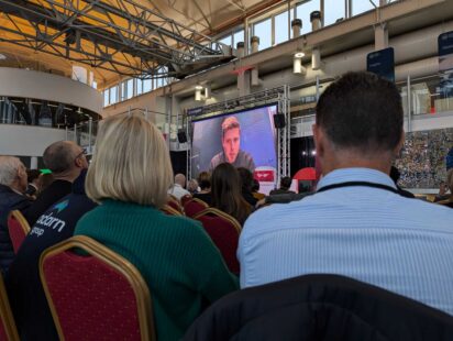 A room of delegates listens to ITV investigations editor Daniel Hewitt present
