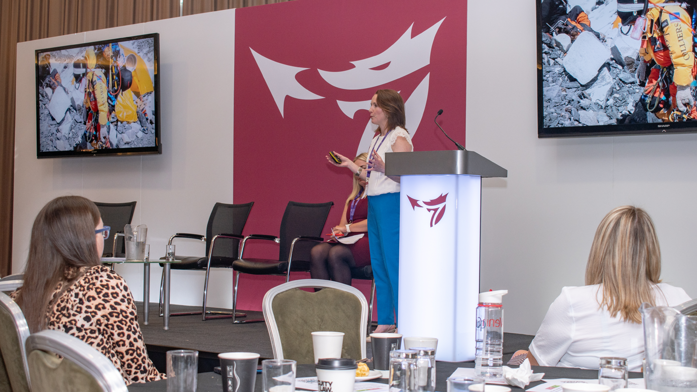 Keynote speaker Tori James on stage speaking at the One Big conference.