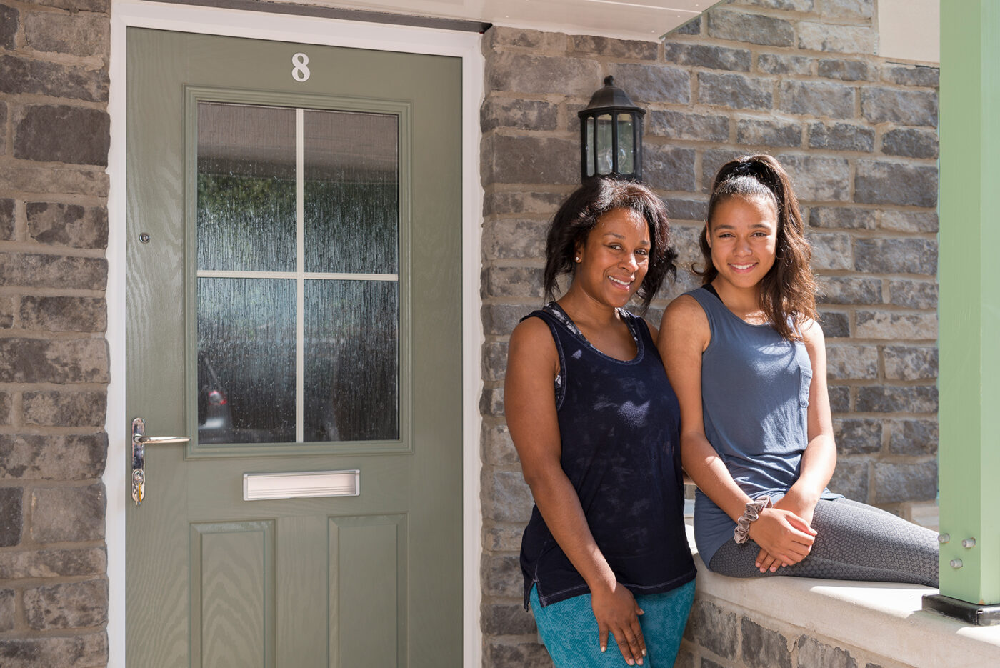 Two Newydd tenants smiling outside their new home